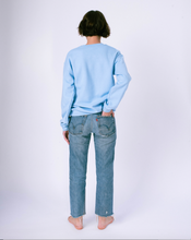 Load image into Gallery viewer, back of light blue crewneck sweatshirt on woman in jeans
