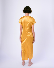 Load image into Gallery viewer, back of gold colored satin maxi tshirt dress with side slit on woman
