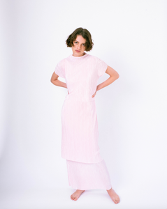 Front of pink pleated tiered maxi dress with mock neck and short sleeves on woman 