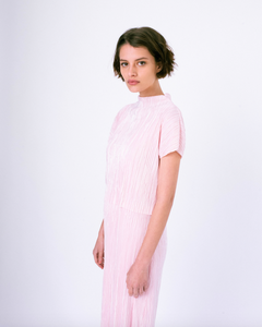 Side profile of pink pleated tiered maxi dress with mock neck and short sleeves on woman