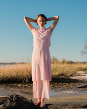 Load image into Gallery viewer, pink pleated tiered maxi dress with mock neck and short sleeves on woman on beach
