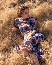 Load image into Gallery viewer, Blue floral print on tan mesh overlay a-line dress with long sleeves over slip dress on woman
