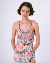 Load image into Gallery viewer, Front detail view of pink floral midi dress with pockets &amp; smocked top . Ruffles on straps and skirt with scoop back

