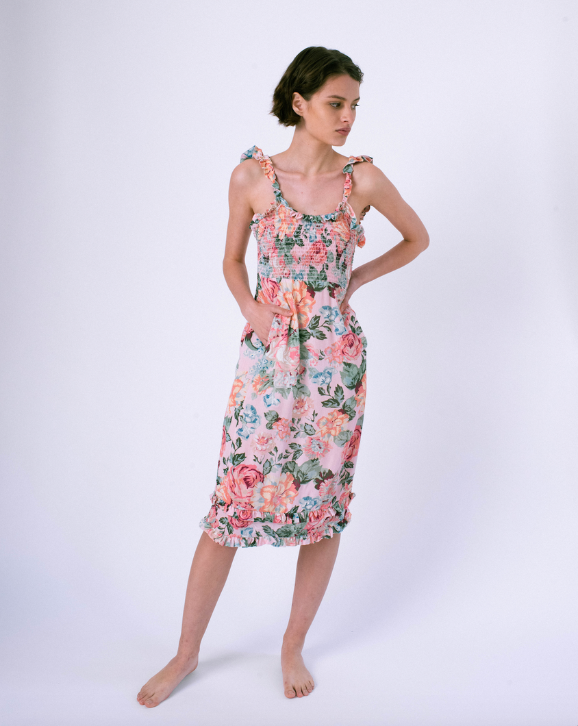 Front of pink floral midi dress with pockets & smocked top . Ruffles on straps and skirt.