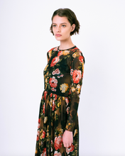 Load image into Gallery viewer, Side profile of floral print brown mesh overlay a-line dress with long sleeves over attached satin slip on woman
