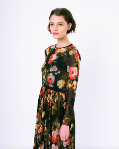 Side profile of floral print brown mesh overlay a-line dress with long sleeves over attached satin slip on woman