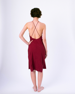 Back view of dark red halter dress with open back & crossed straps on woman